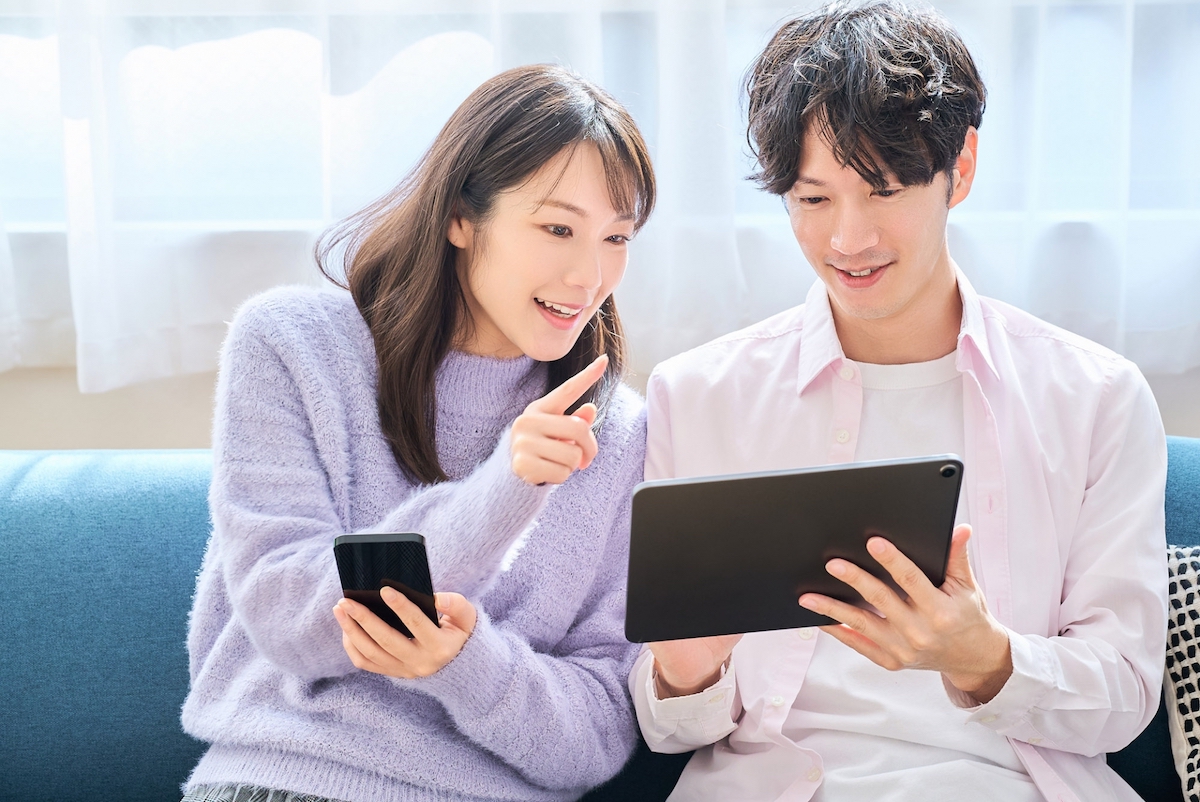 男女がタブレット端末で相談している様子の写真