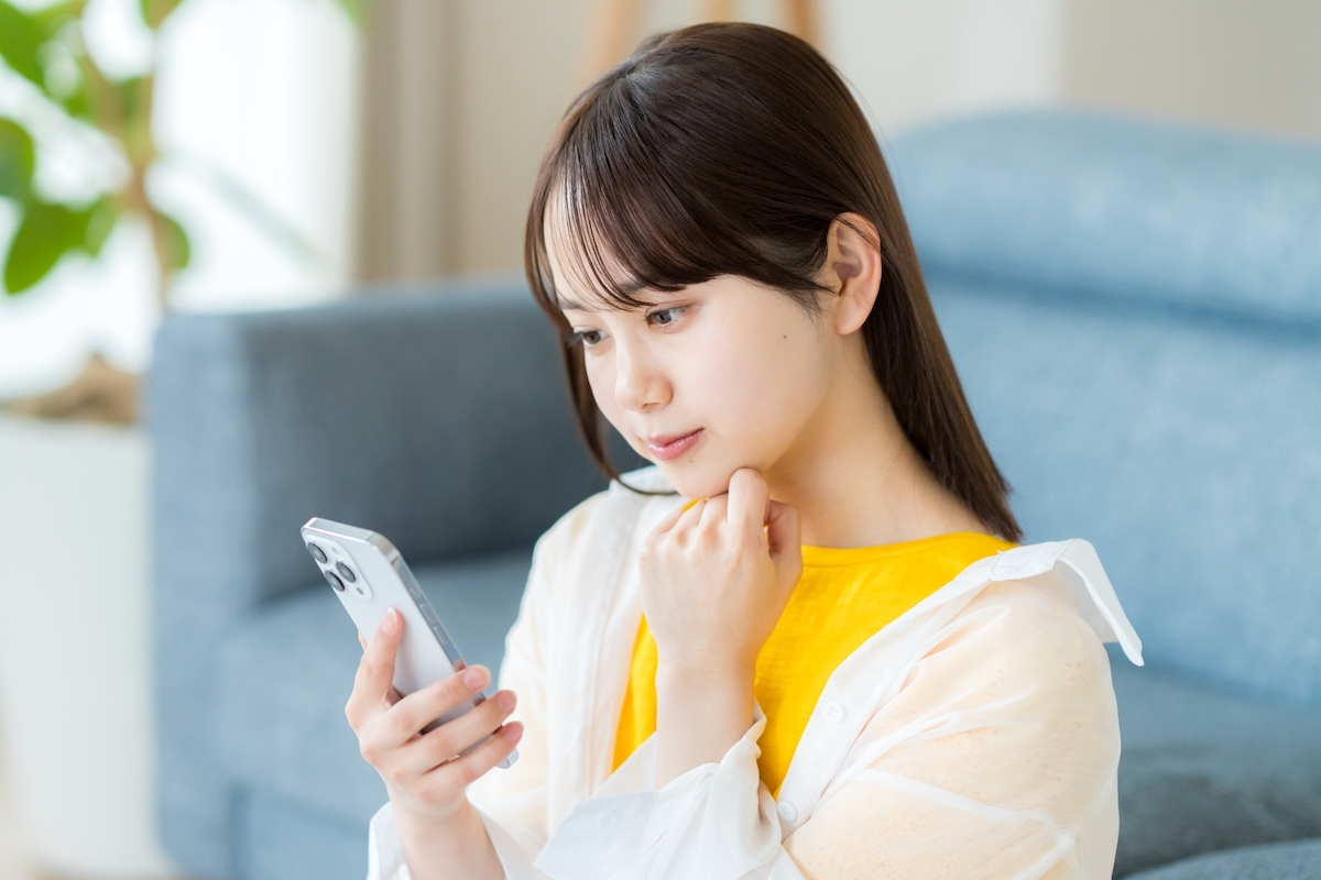 女性がスマートフォンを見ている写真